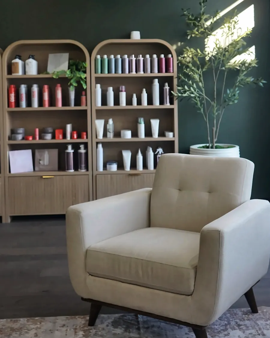The Quin's lobby: a cream armchair before arched retail shelves and a sunlit window